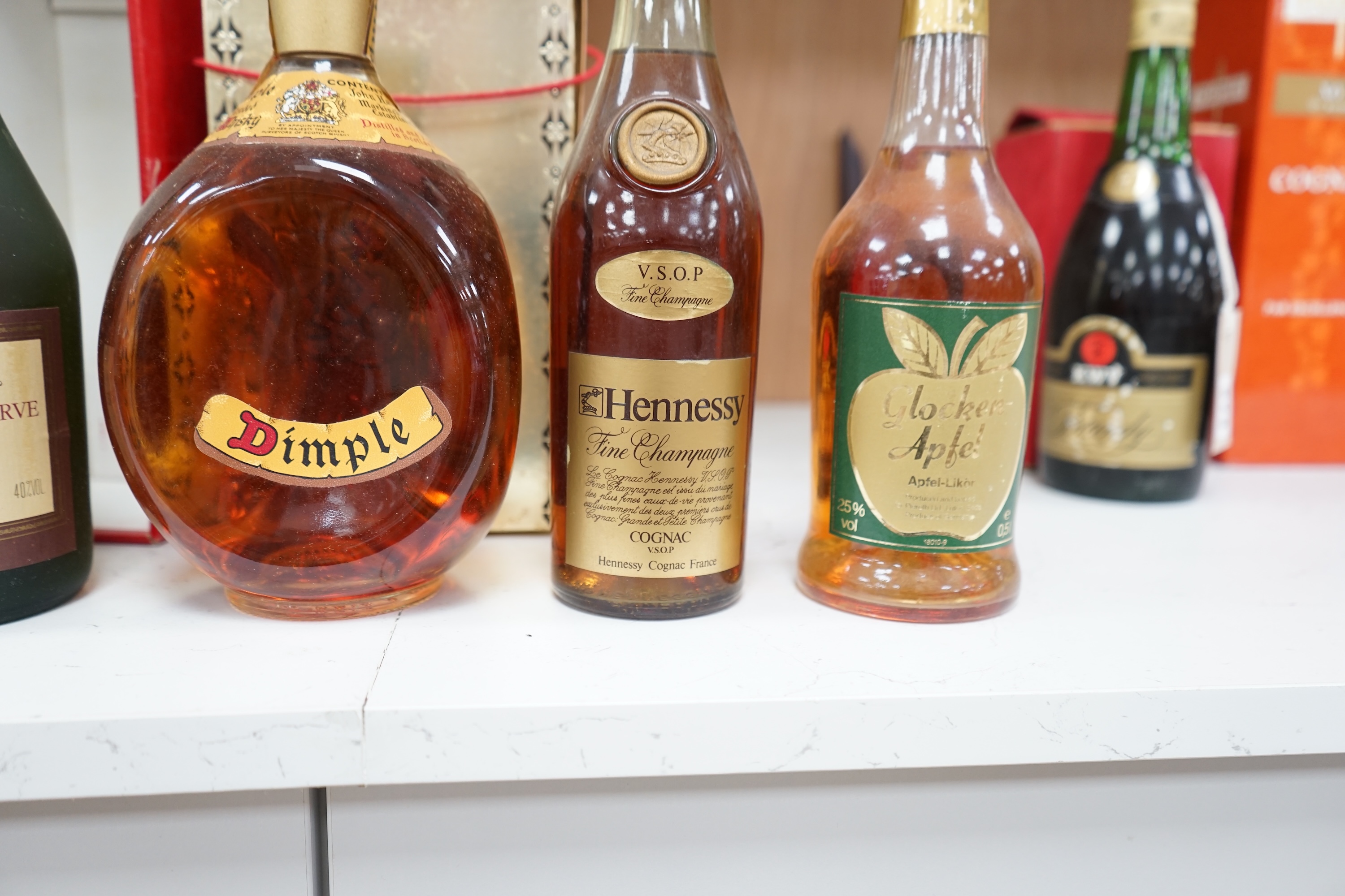 Four bottles of various alcohols comprising a bottle of 50cl Hennessey Fine Champagne Cognac, Planty Fine Cognac, Dimple Scotch Whisky and Glocken Apfel. Condition - fair, storage history unknown